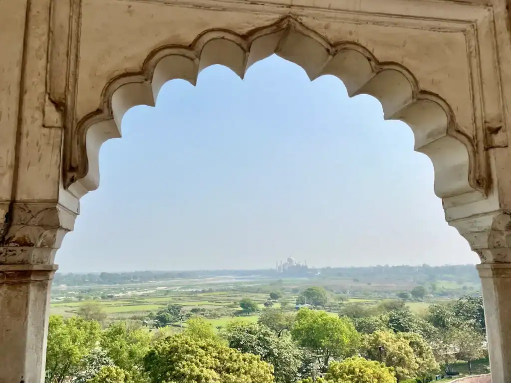 Scenic view of Indian landscape through ornate archway.
